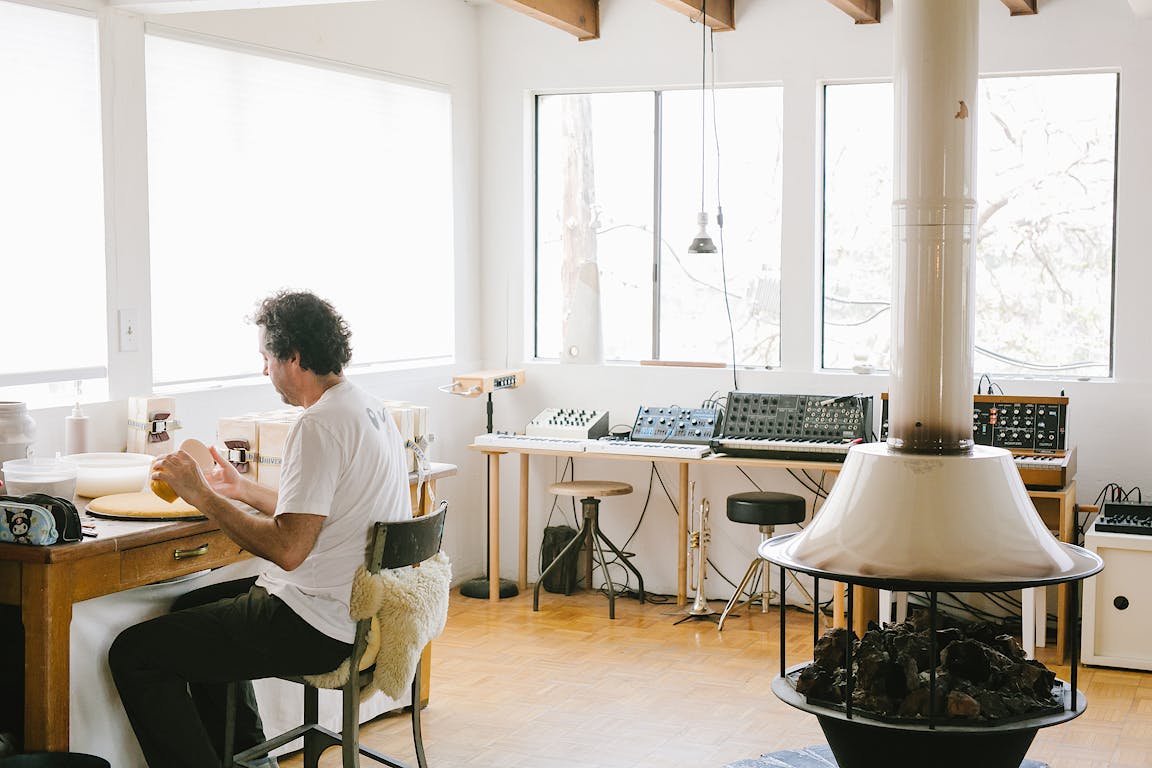 A person works in a brightly lit ceramic studio.